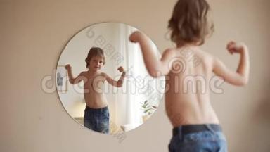 <strong>自信</strong>的<strong>孩子</strong>看着镜子里的肌肉想象他是超级英雄